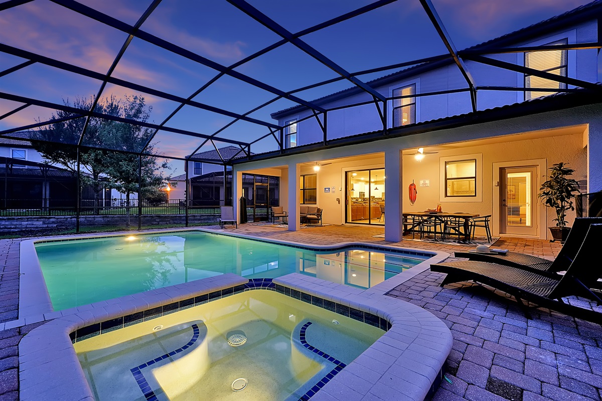 Screened pool and spa at a ChampionsGate villa at dusk